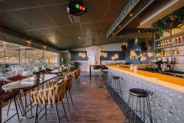 Sirius Samos cocktail bar interior featuring a classical sculpture and sea view