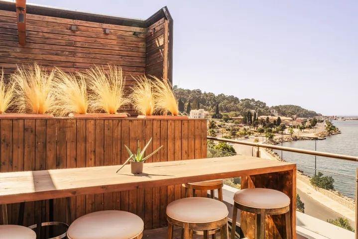 Wooden terrace seating at Sirius Samos with panoramic coastal view